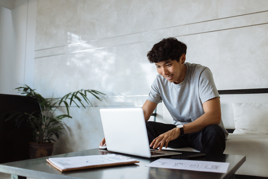 A man sitting at a table with a laptop.